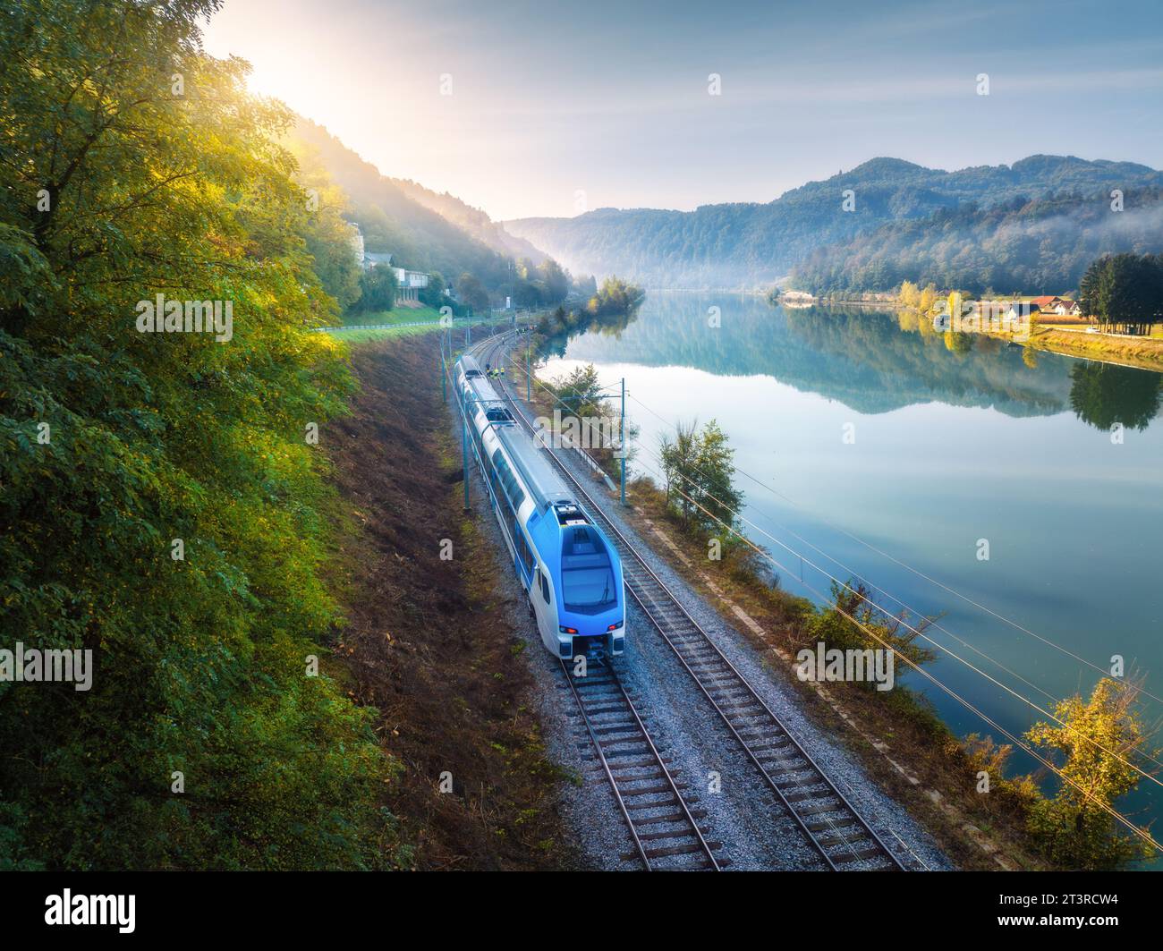 Aerial view of blue speed train moving near river in mountains Stock ...