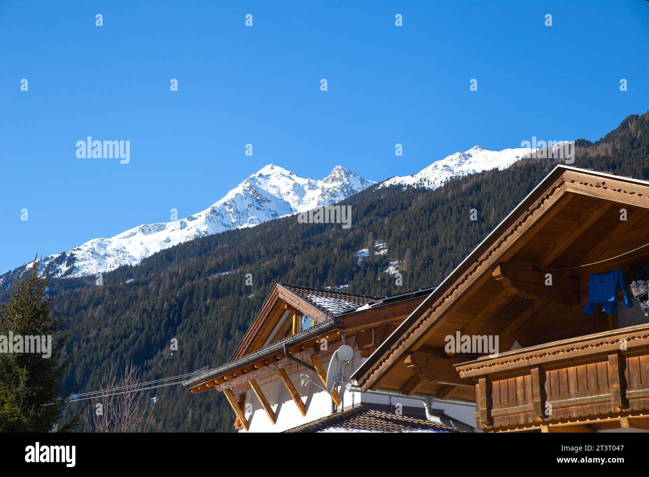 a typical Alpine style wooden roof with snow mountain in the background in Neustift im Stubaital, Austria Stock Photo