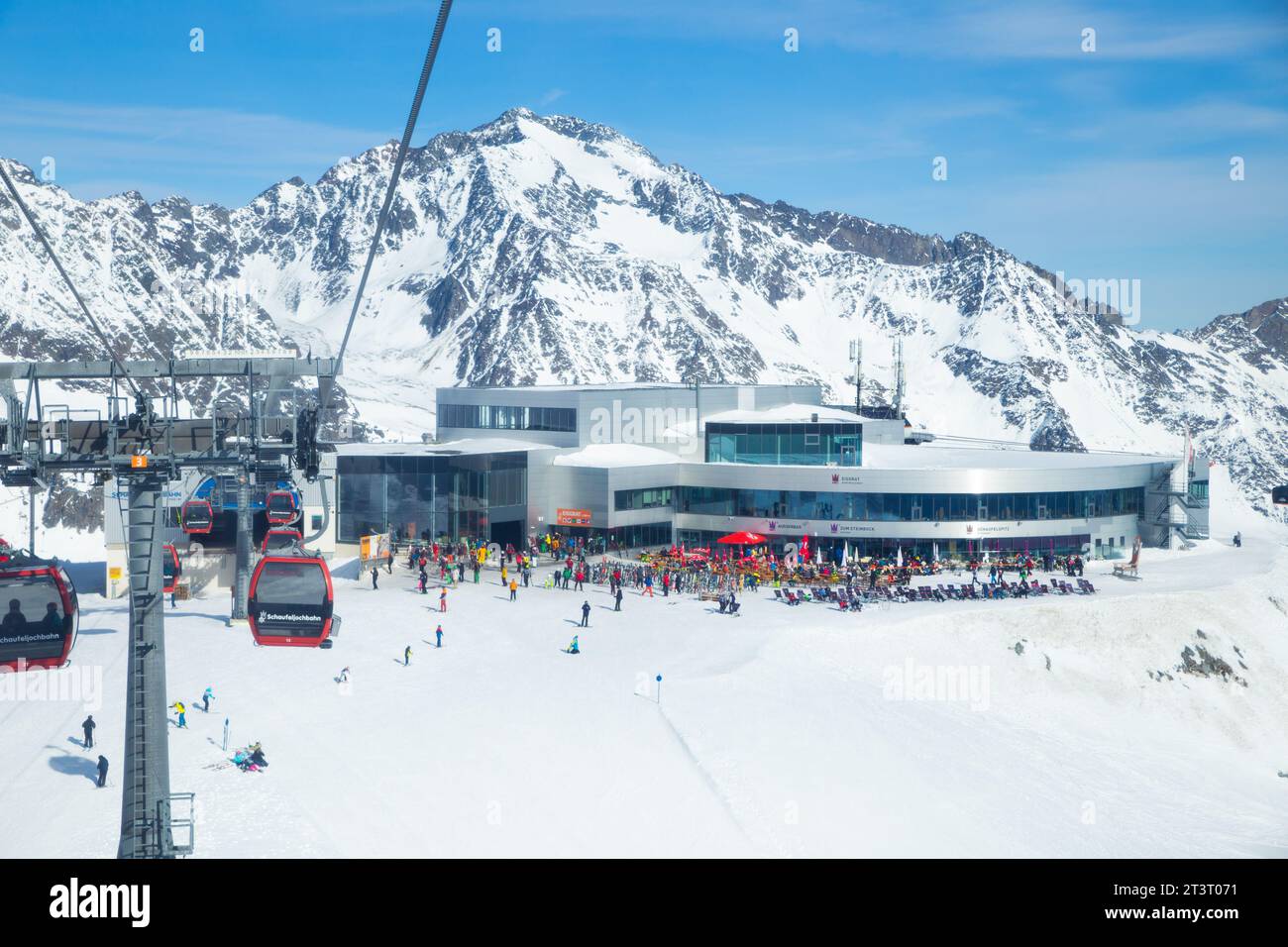 Aerial view of  Eisgrat station and cable cars in the background of snowy mountain range, Neustift im Stubaital, Austria Stock Photo