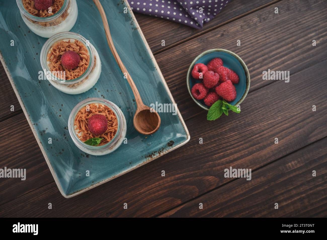 Dessert panna cotta with caramel cheese and fresh raspberry on wooden background Stock Photo