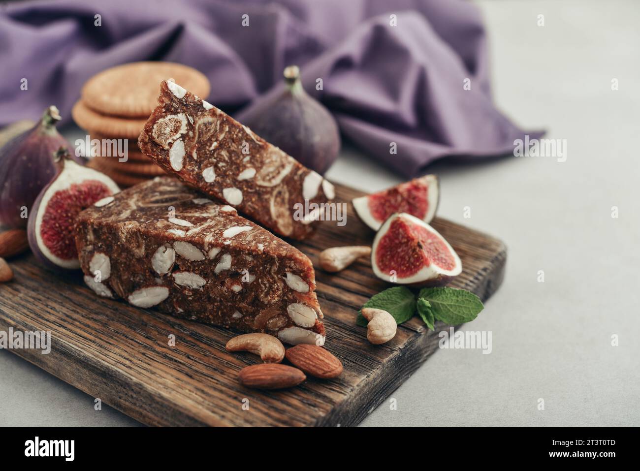 Pan de Higo - Spanish fig bread at wooden cutting board with fresh figs and almond closeup Stock Photo
