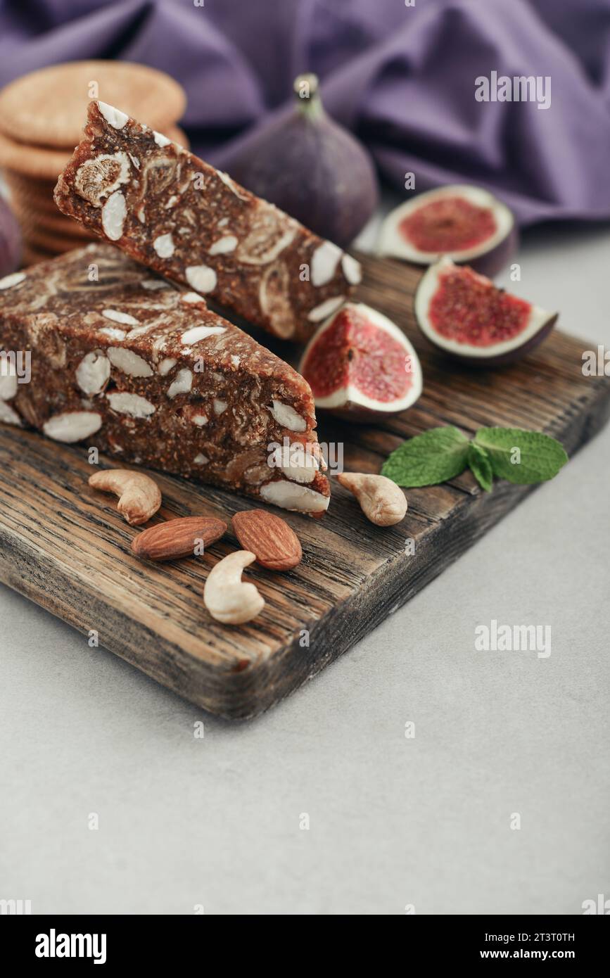 Pan de Higo - Spanish fig bread at wooden cutting board with fresh figs and almond closeup Stock Photo