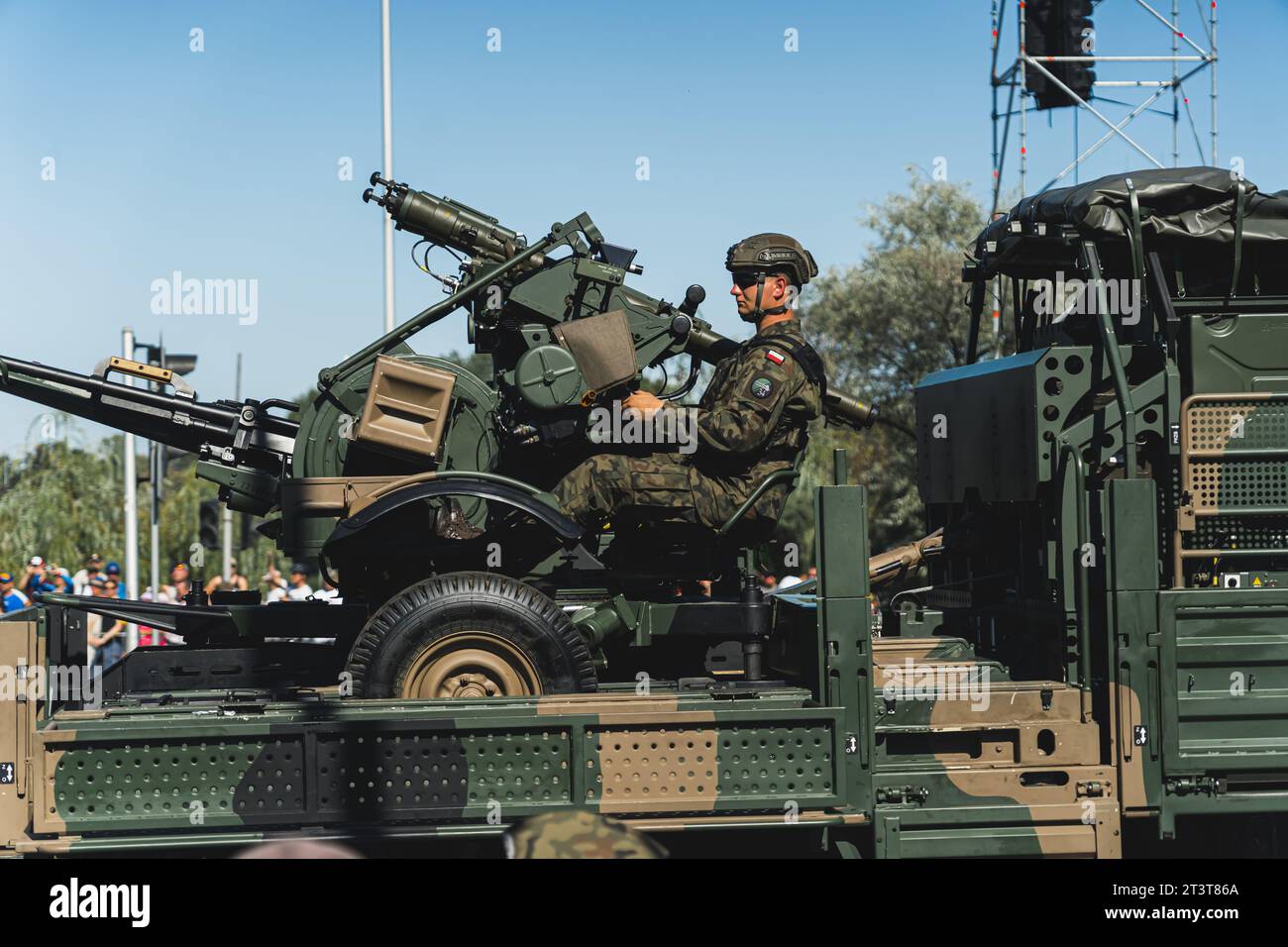 16.08.2023 Warsaw, Poland. Armed Polish soldier in camouflage uniform driving military machine with a gun. Open-air military parade concept. High quality photo Stock Photo