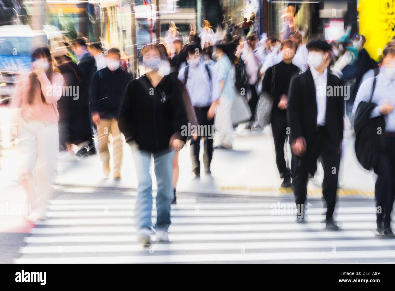 picture with motion blur effect of crowds of people crossing a city ...