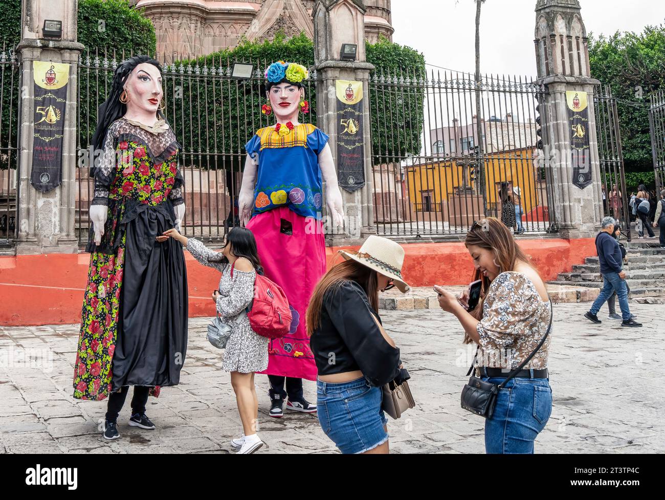 October 26, 2023, San Miguel de Allende, San Miguel de Allende, Mexico: People seen infront of giant puppets called mojigangas in San Miguel de Allende, Mexico on February 26, 2023. (Credit Image: © Ronen Tivony/ZUMA Press Wire) EDITORIAL USAGE ONLY! Not for Commercial USAGE! Stock Photo