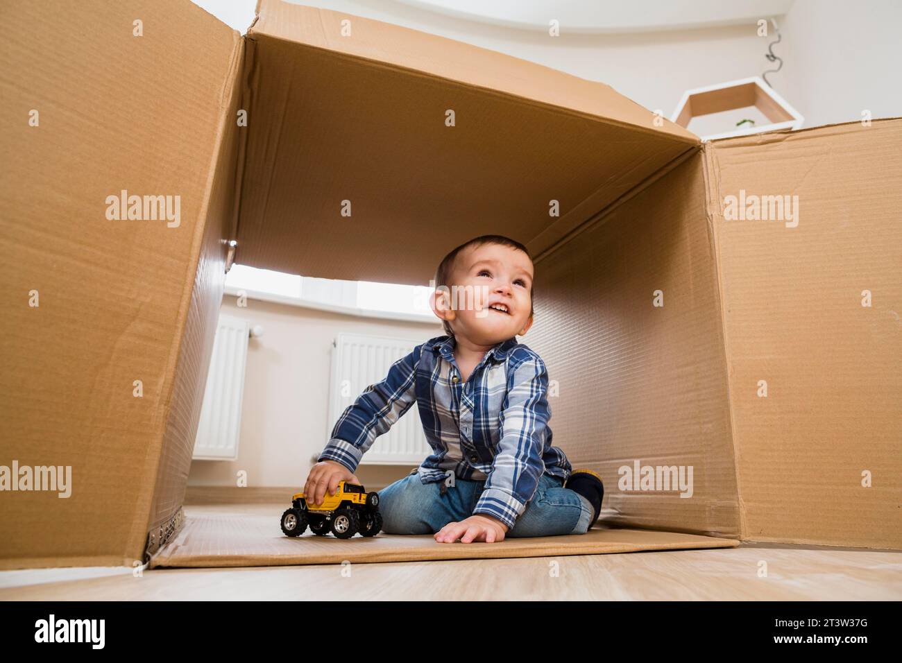 Portrait smiling toddler boy playing with toy vehicles Stock Photo