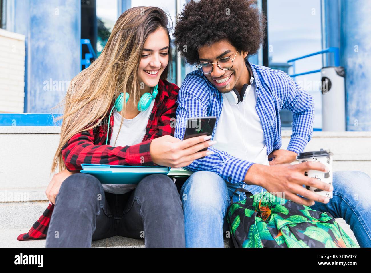 Portrait smiling diverse young students looking mobile phone Stock Photo