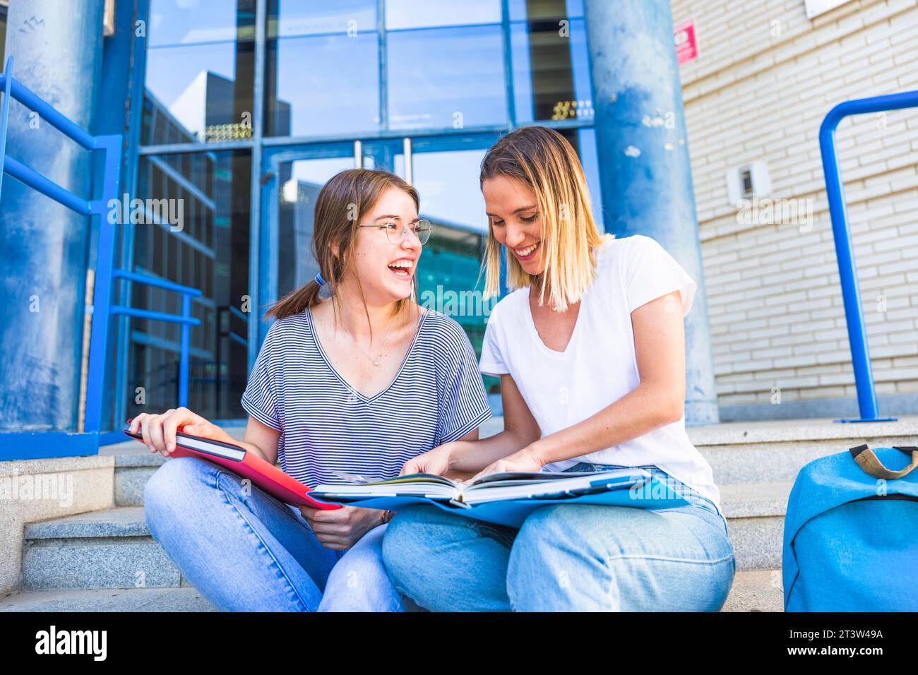 Women reading textbook laughing Stock Photo