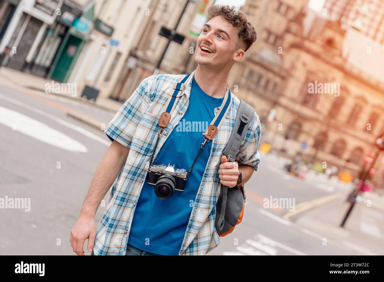 Outdoor portrait of man using a camera and taking photos in the city of Europe. Enjoying travel concept Stock Photo