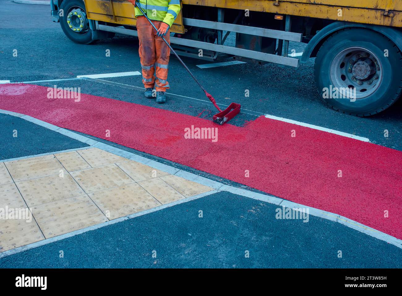 Road workers applying hot melt traffic resistant paint for white