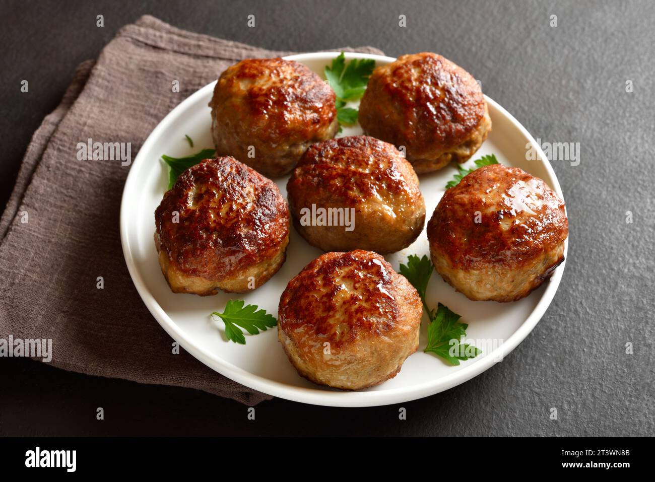Homemade cutlets from minced meat on plate over dark background. Close up view Stock Photo