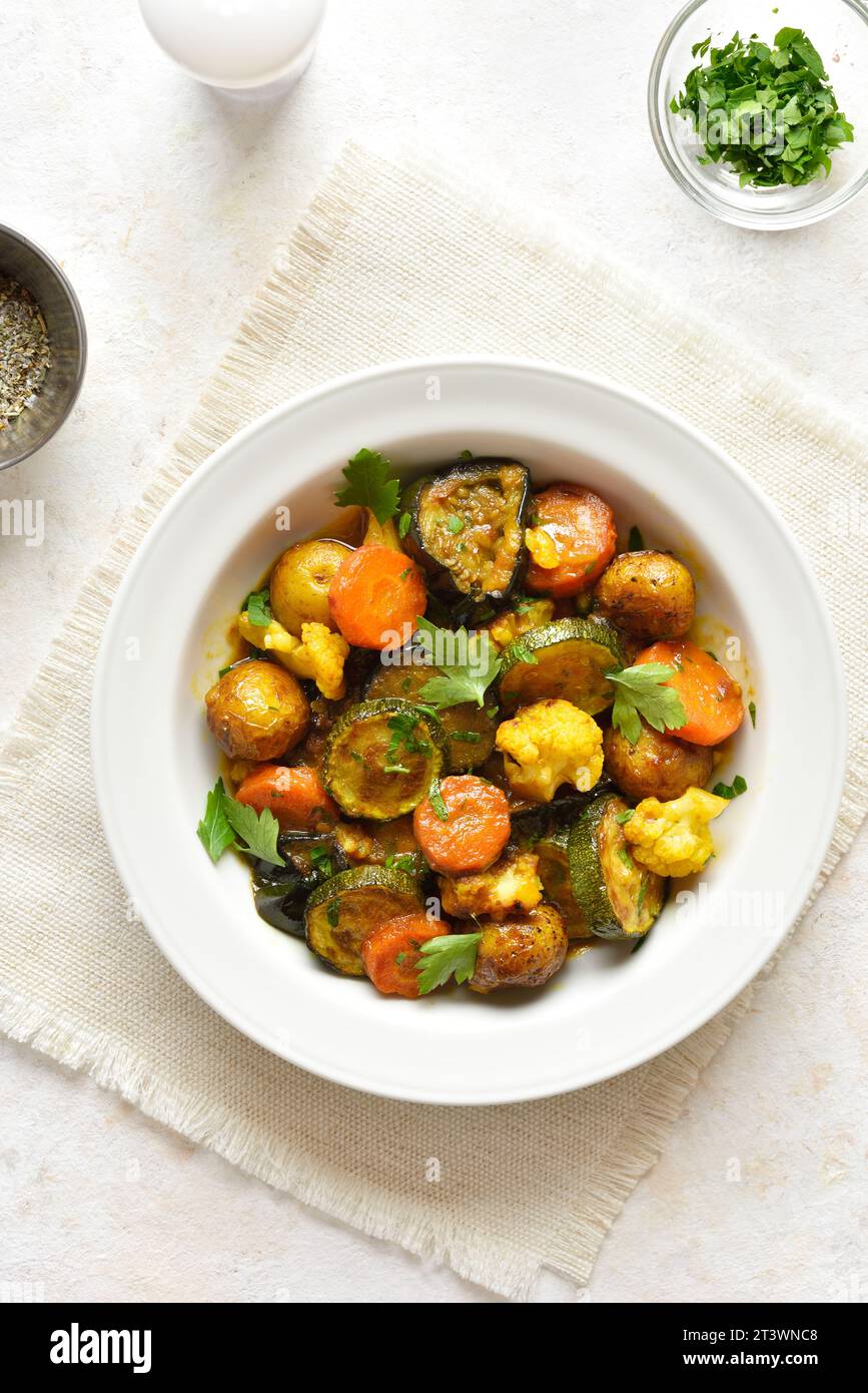Diet stewed vegetables in bowl over light background. Vegetarian vegan or healthy eating concept. Top view, flat lay Stock Photo