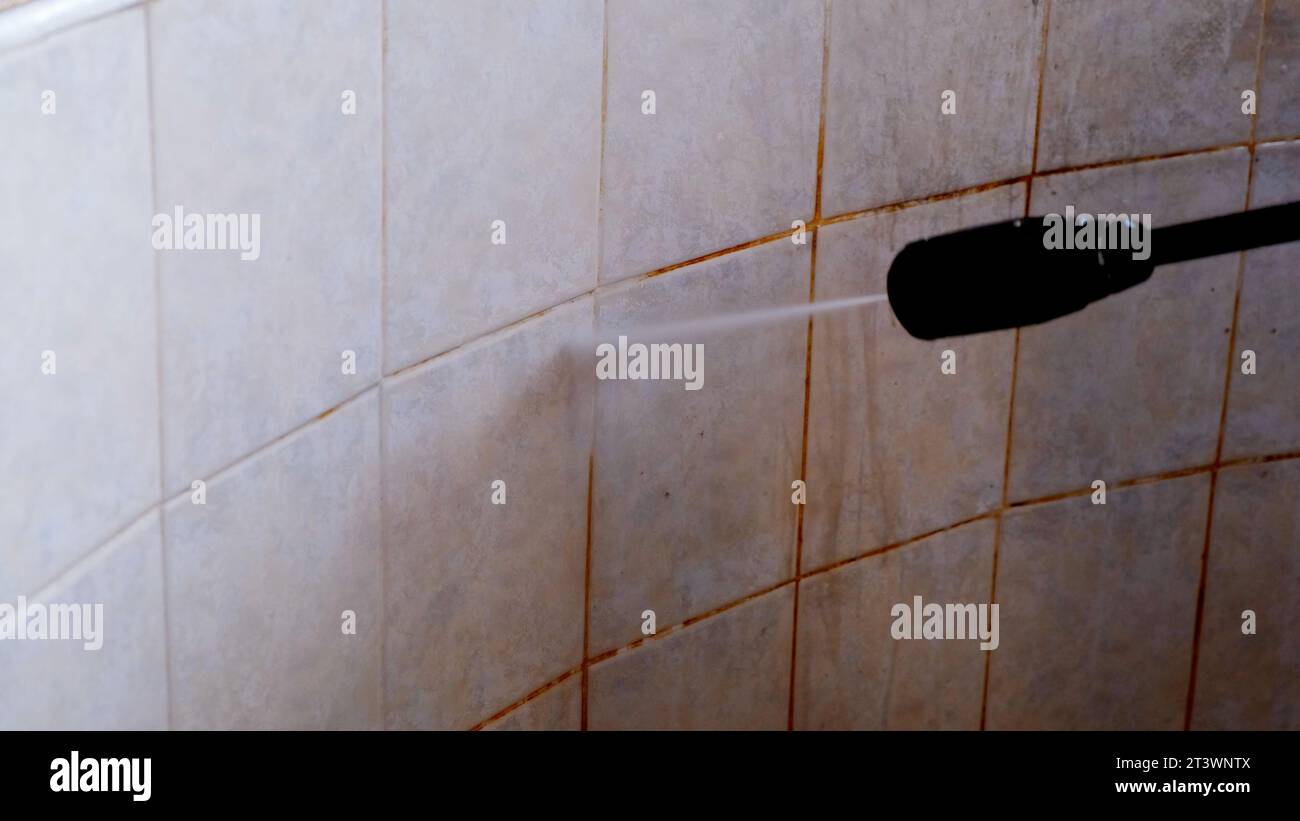 Cleaning dirty tiles with water pressure washer. Concept of a cleaning