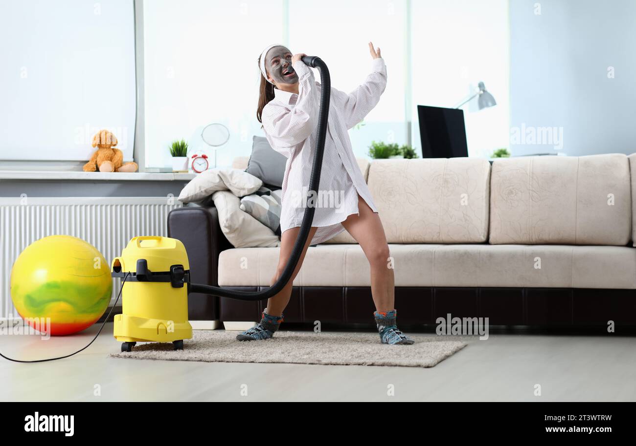 Woman sing song in vacuum cleaner against modern Stock Photo - Alamy