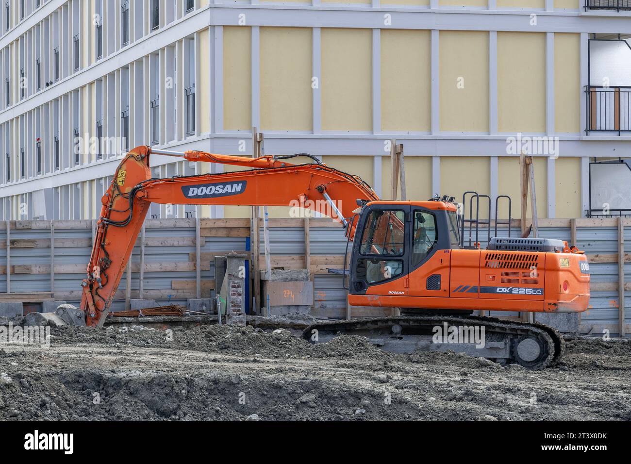 Le Havre, France - Orange crawler excavator Doosan DX225LC on construction site. Stock Photo