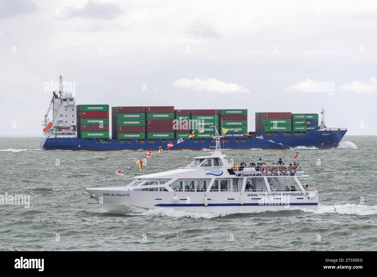 Le Havre, France - Passenger ship VILLEDUHAVRE II crosses in front of a container ship in English Channel. Stock Photo