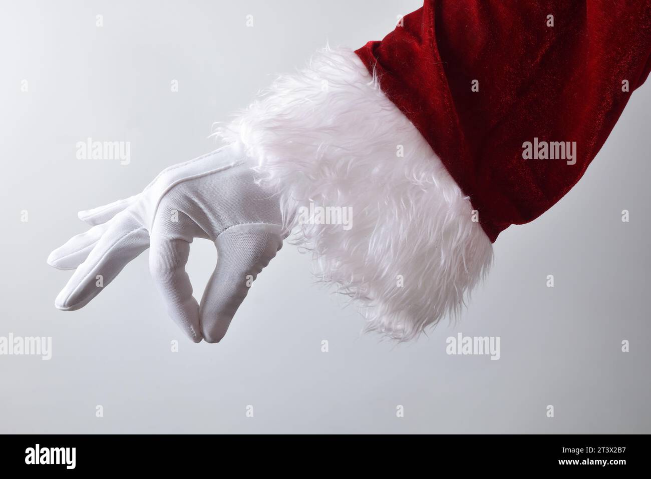 Santa claus hand with white glove and red traditional costume making