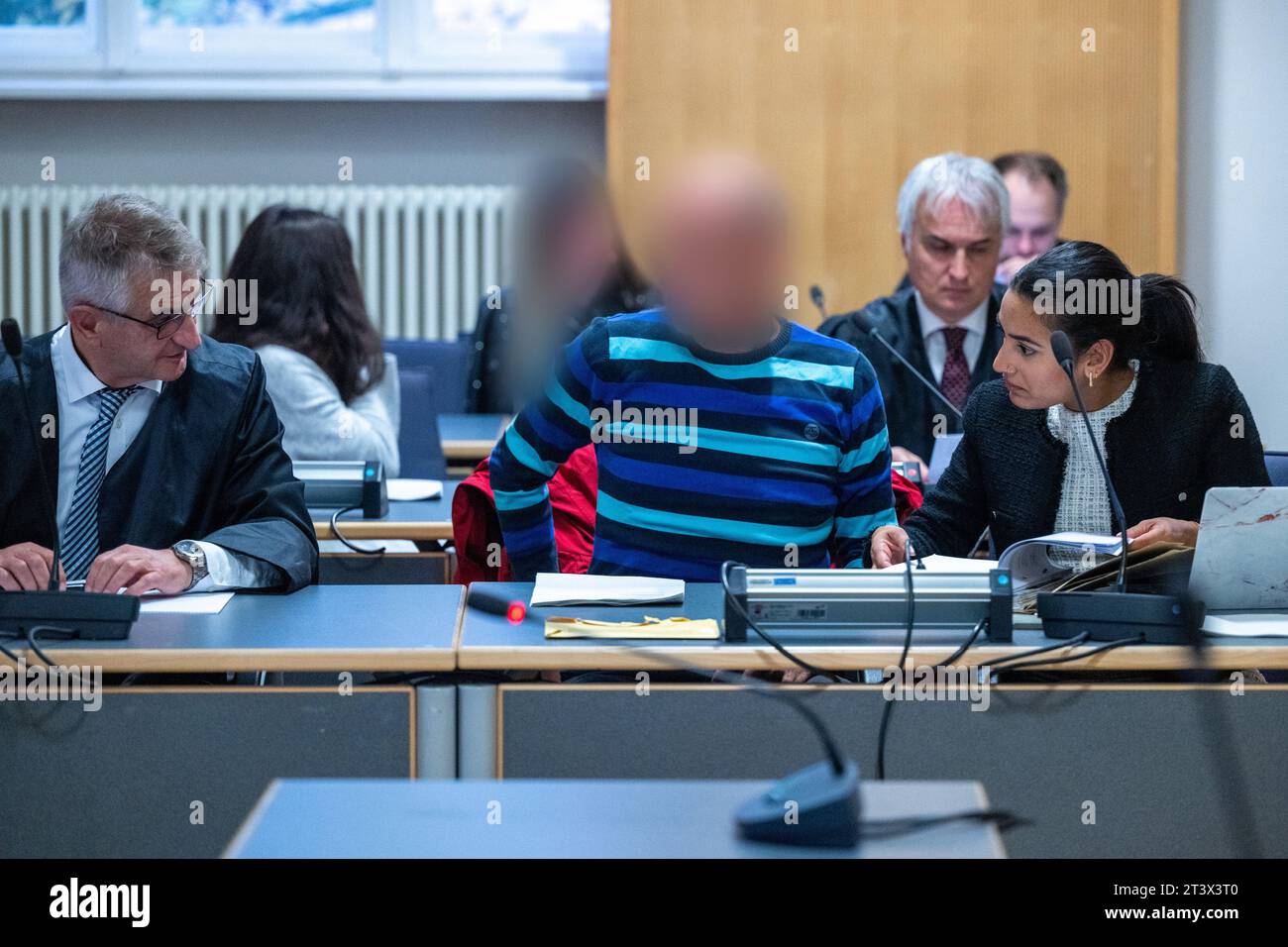 Regensburg, Germany. 27th Oct, 2023. The three defendants sit between ...