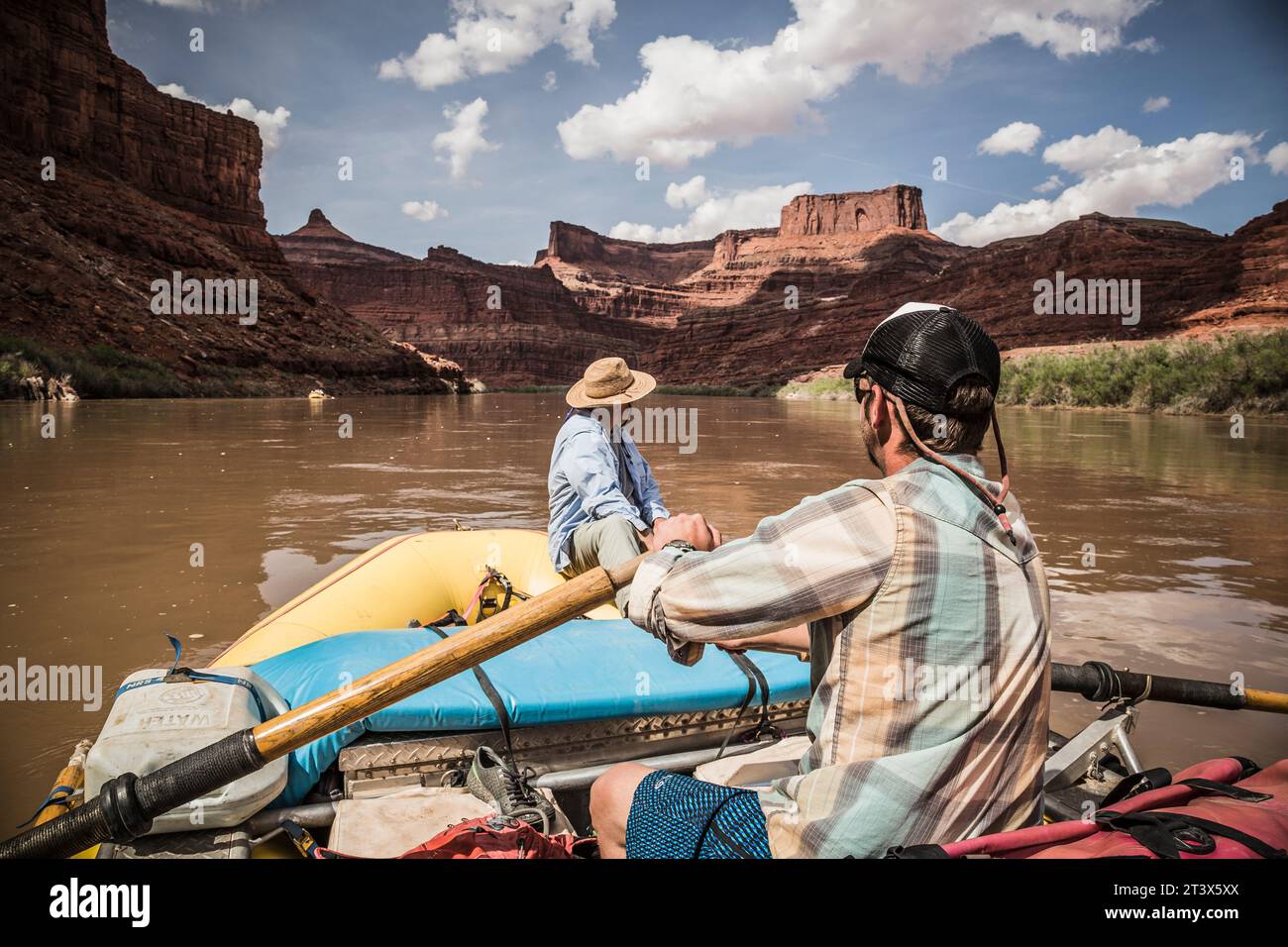 A man rows a raft down a river in a desert landscape Stock Photo - Alamy