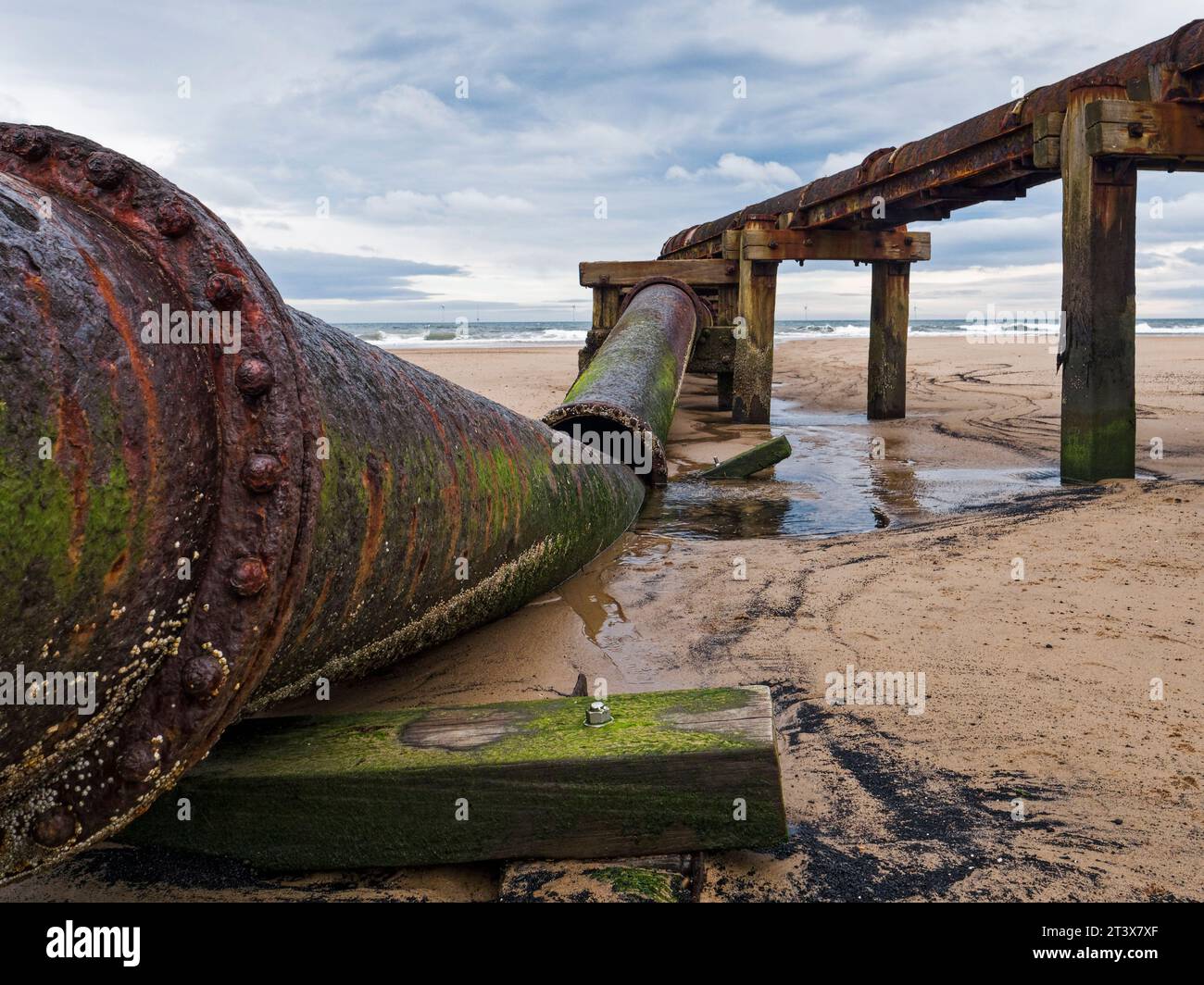 Old broken pipe on Cambois beach, Northumberland, UK Stock Photo