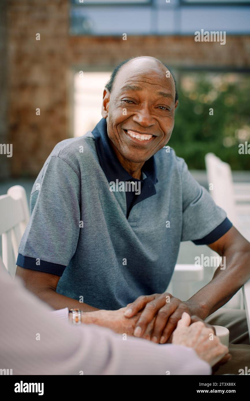 Portrait of happy senior man sitting with woman Stock Photo