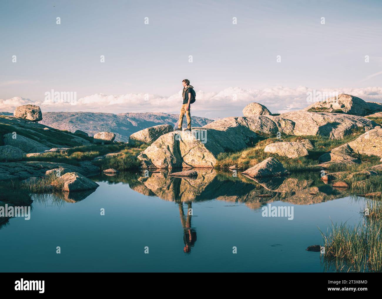 man on the shore of a mountain lake in Norway Stock Photo