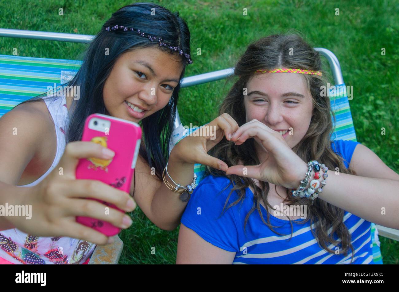 Teen girls together on phones having fun Stock Photo