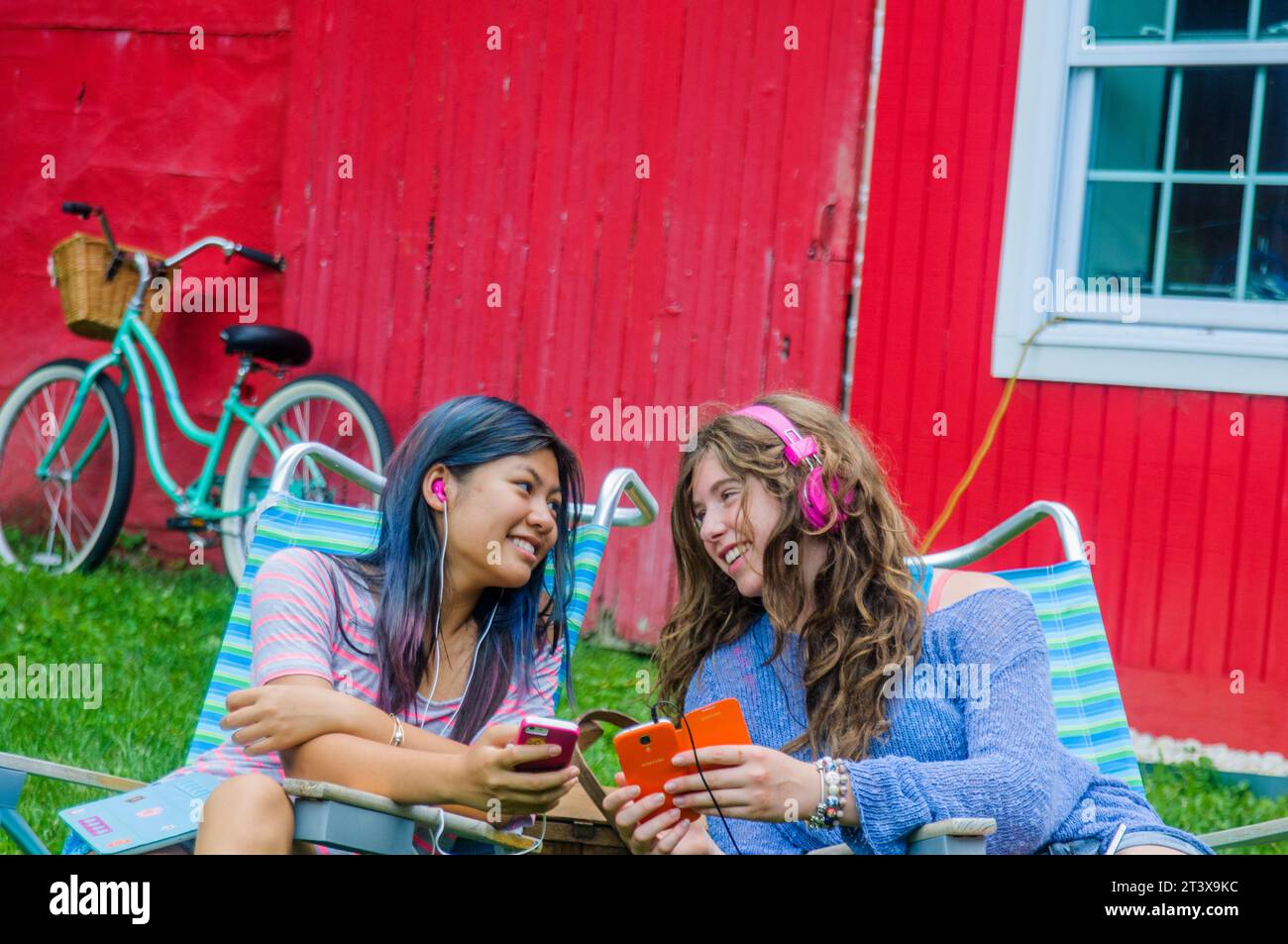 Teen girls together on phones having fun Stock Photo