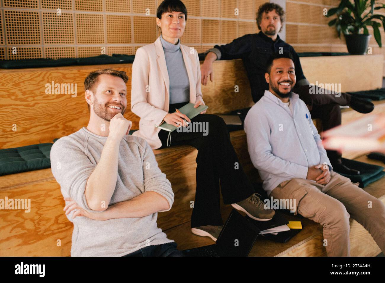Smiling multiracial colleagues sitting in office during meeting Stock Photo