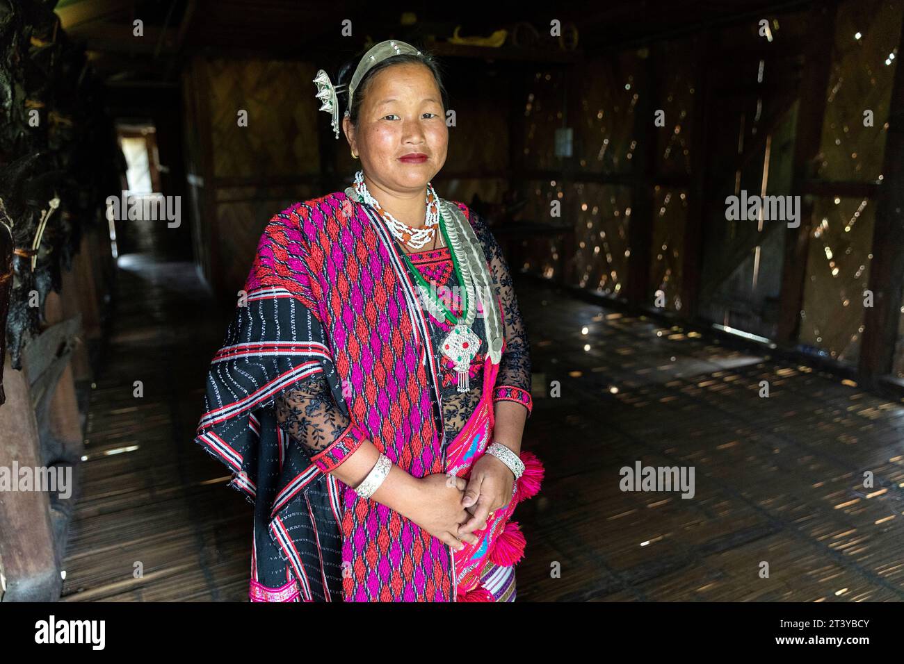 Woman from Adi tribe in traditional adi clothes posing in her traditional wooden house in Assam in Northeast India Stock Photo