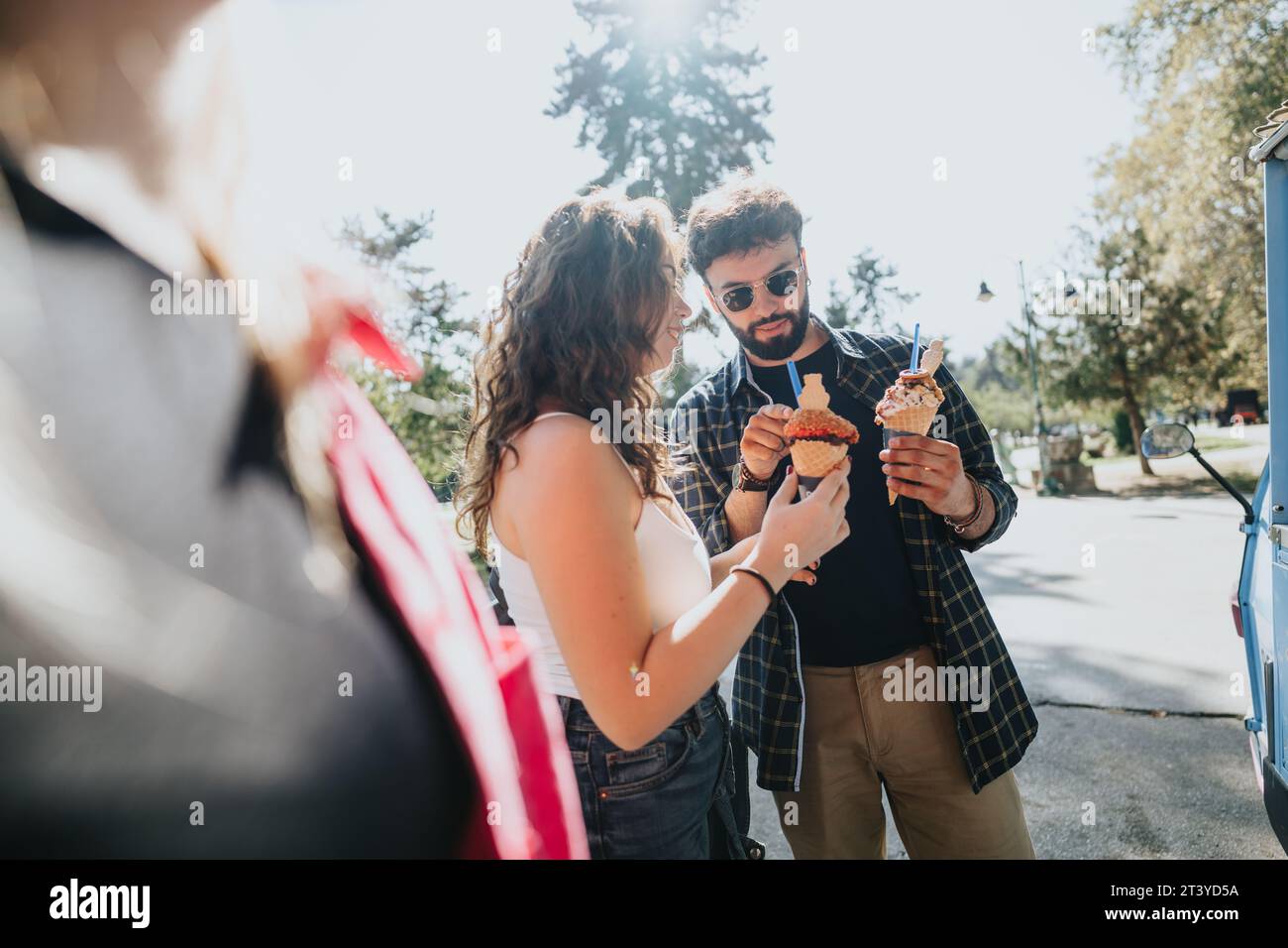 Carefree friends enjoying a sunny day in the park, eating ice cream ...