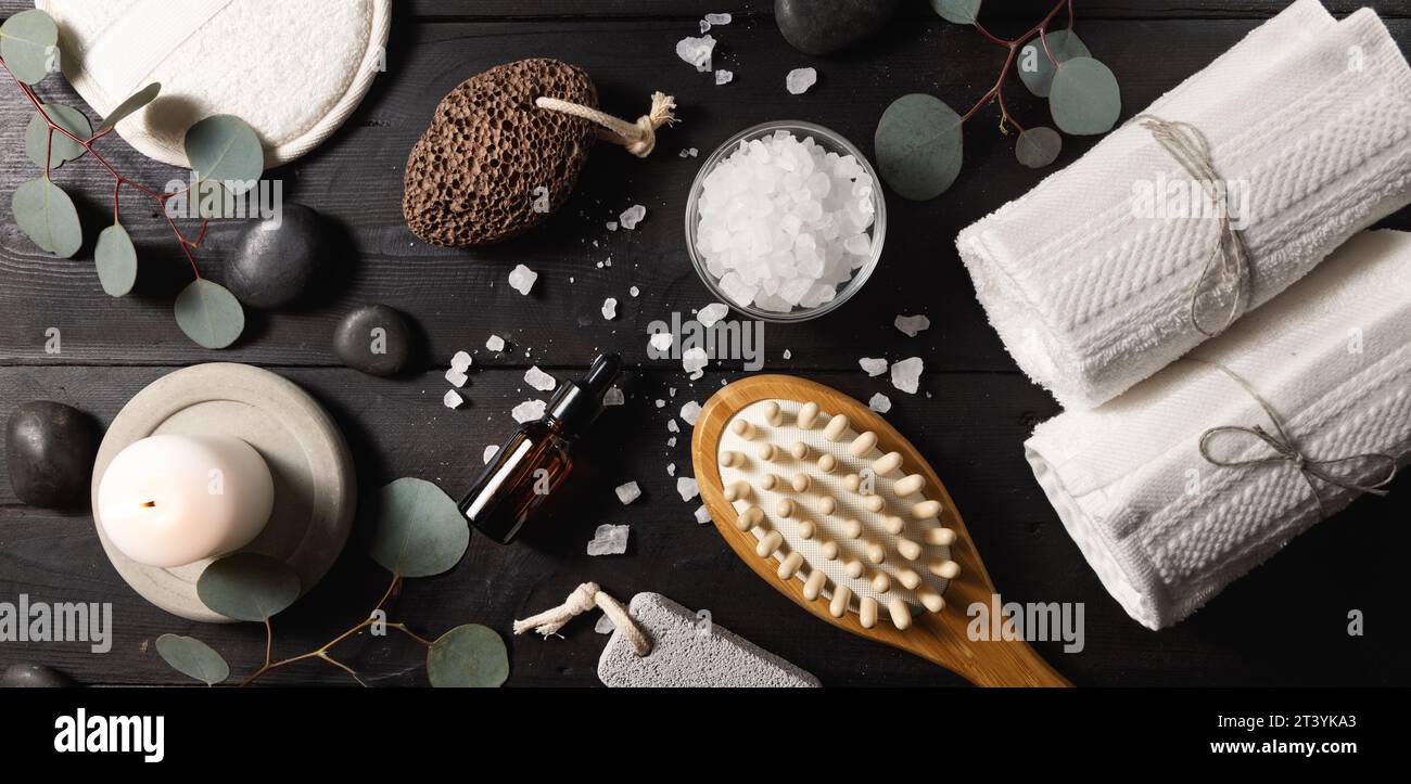 spa treatment. skin care items for bath procedures on dark black wooden table. body wellness. top view banner Stock Photo