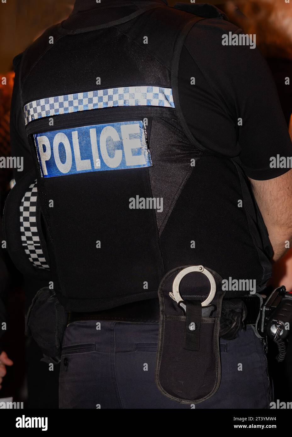 The word “Police” on the back of a policeman’s uniform jacket, handcuffs also in the picture Stock Photo