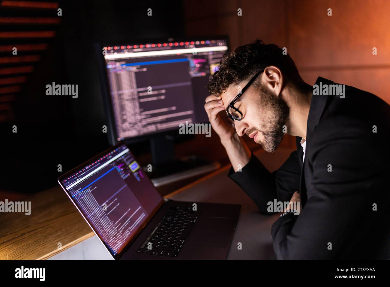 Young man mobile developer writes program code on a computer, programmer work in home office. Stock Photo