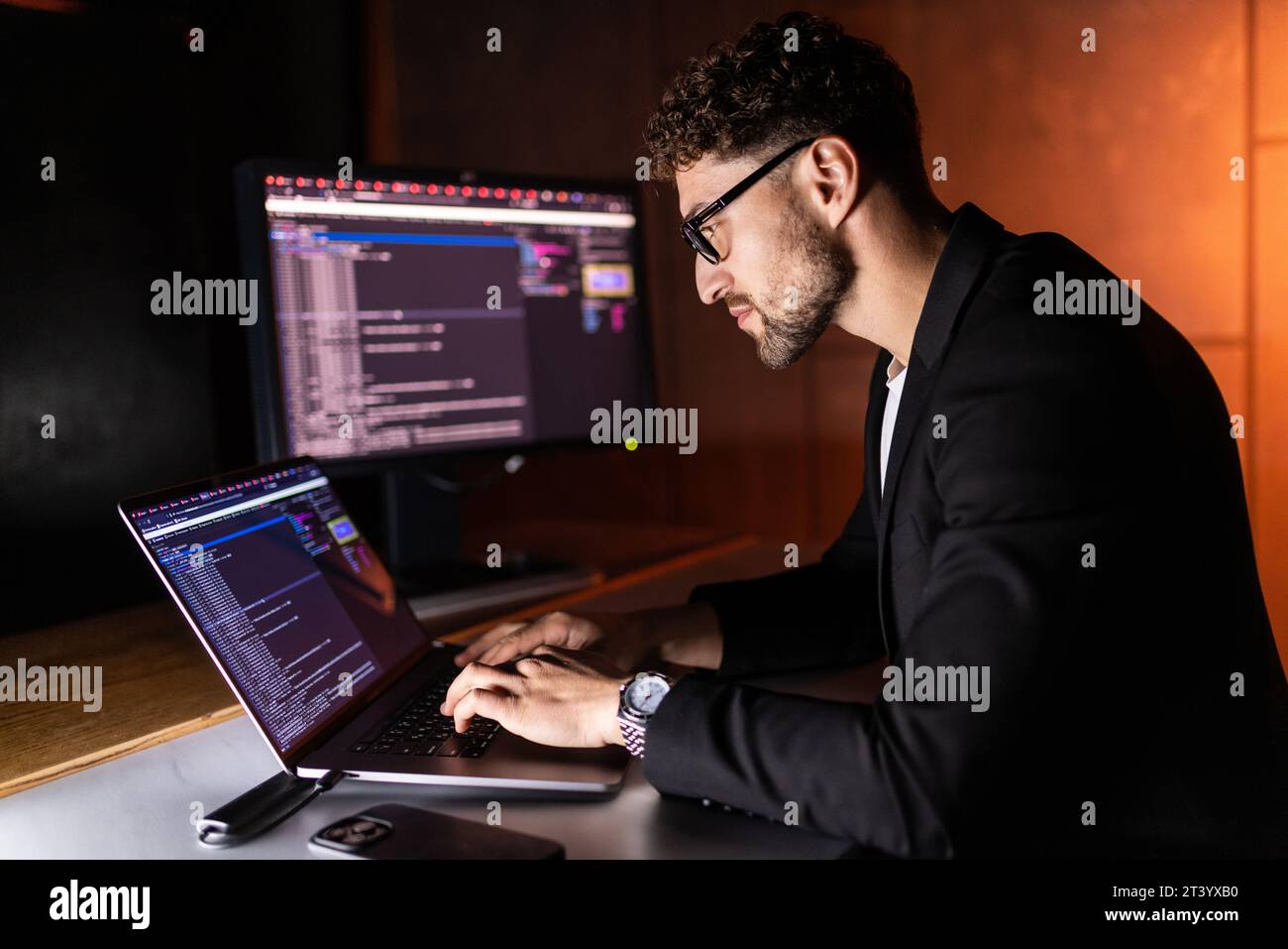 Handsome young programmer working at home late in evening Stock Photo
