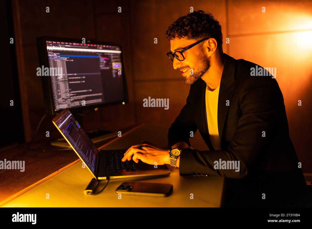 Handsome young programmer working at home late in evening Stock Photo