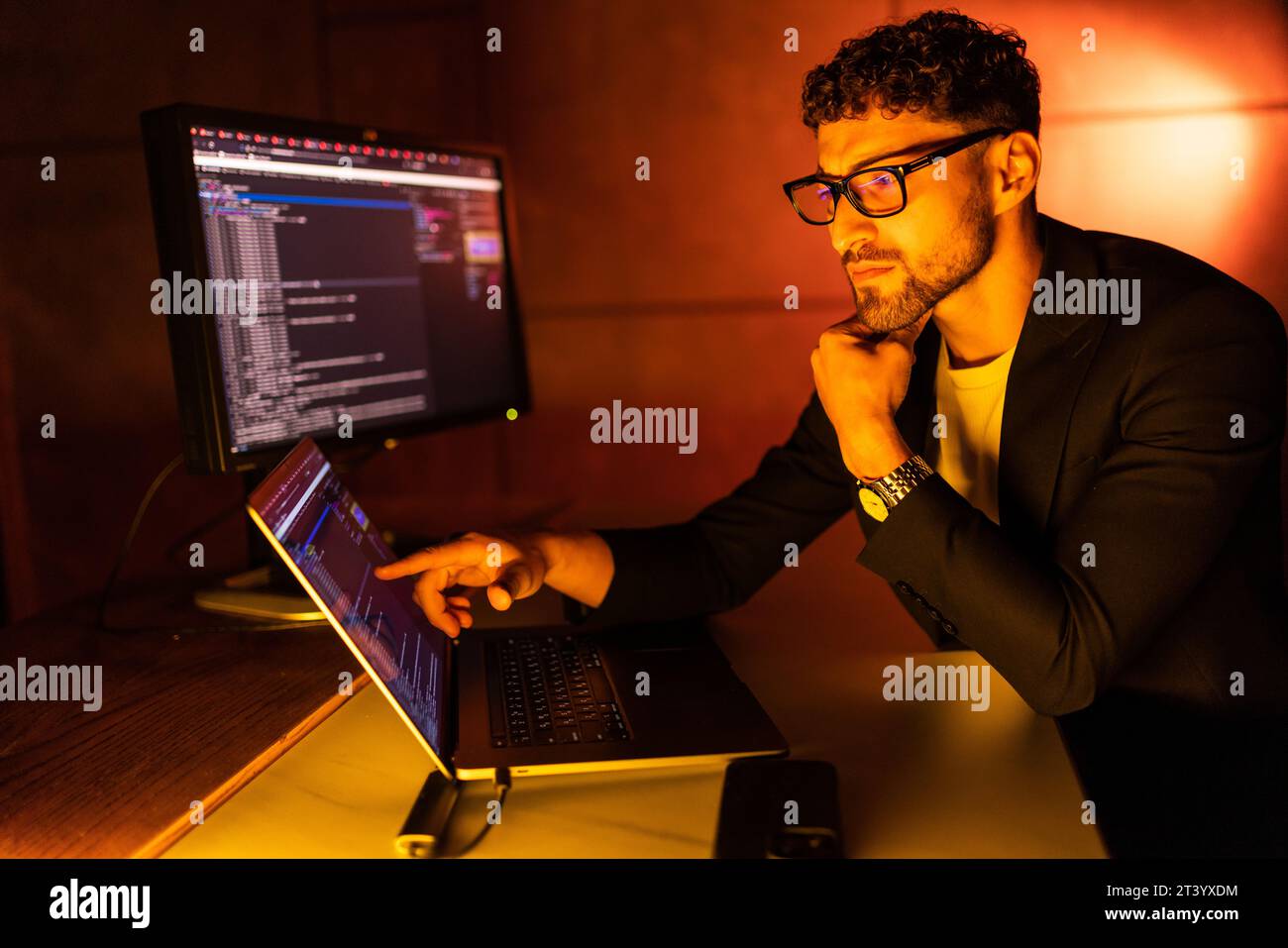 Wanted hackers coding virus ransomware using laptops and computers. Stock Photo