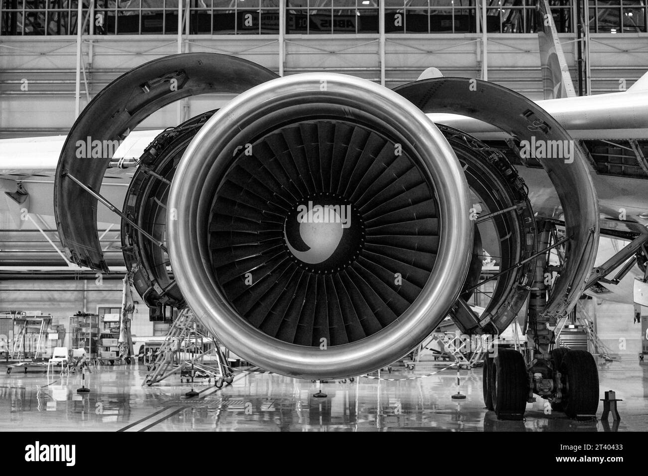 Close-up shot of an airplane's disassembled turbine in the hangar. Disassembly and repair are in progress.Front view. Black and white. Stock Photo
