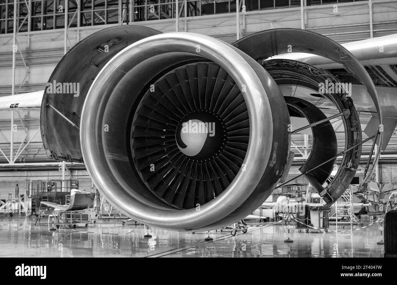 Close-up shot of an airplane's disassembled turbine in the hangar. Disassembly and repair are in progress. Black and white photo. Stock Photo