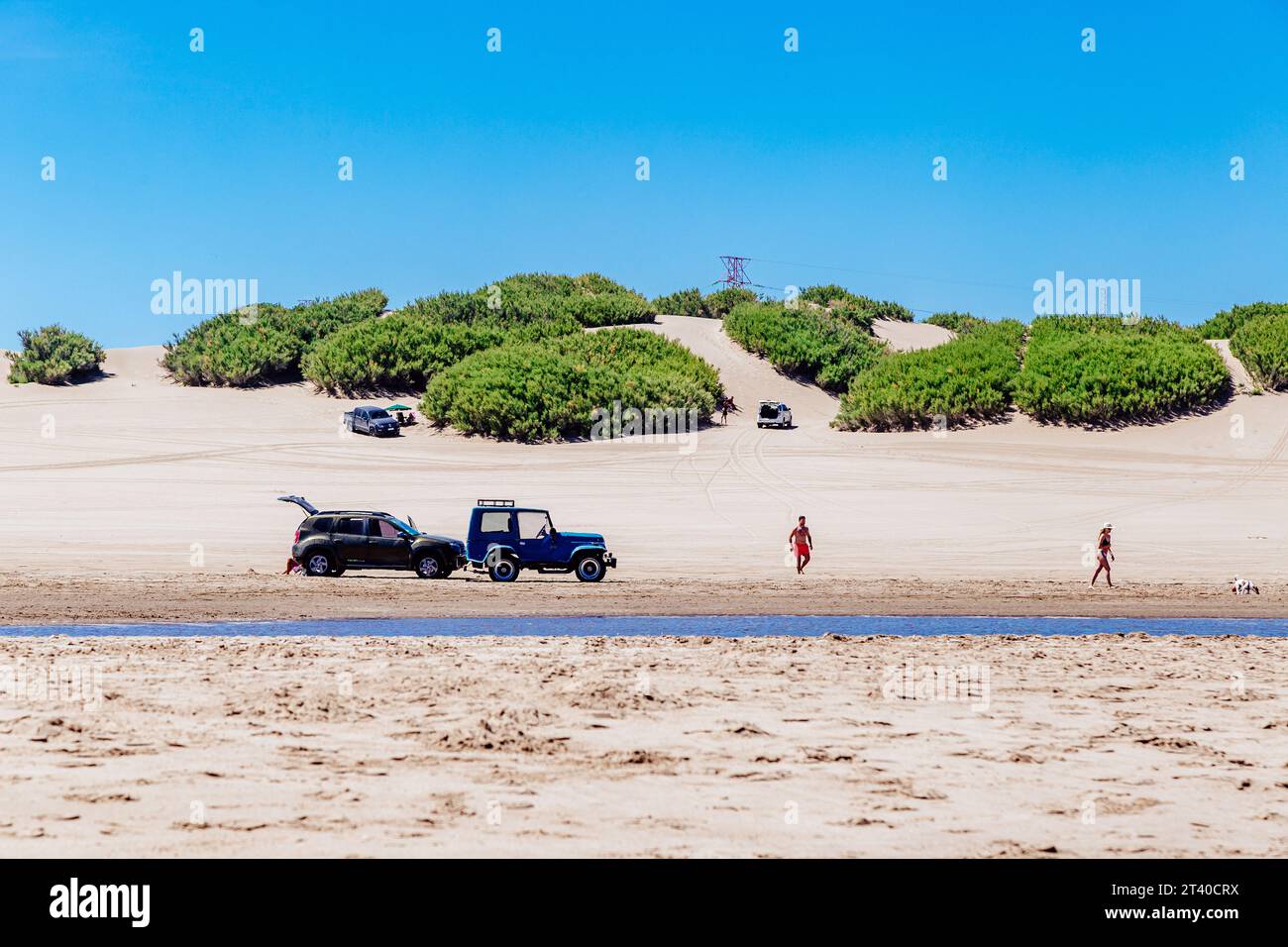 NECOCHEA, BUENOS AIRES, ARGENTINA - JANUARY 5, 2022: view of the Los Patos beach from the seaside. Vehicles and people over the sand. Beautiful dunes Stock Photo