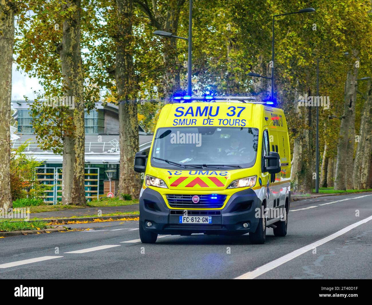 Private ambulance with blue lights flashing speeding through Tours, Indre-et-Loire (37), France. Stock Photo