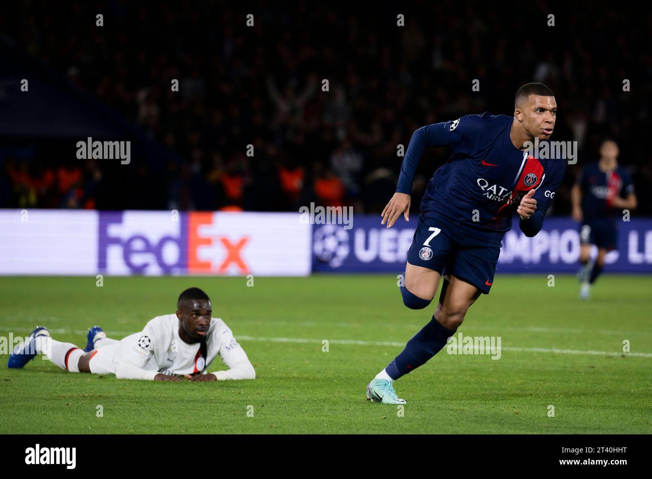 Kylian Mbappe of Paris Saint Germain FC celebrates after scoring the opening goal as Fikayo Tomori of AC Milan looks dejected during the UEFA Champions League football match between Paris Saint Germai...
