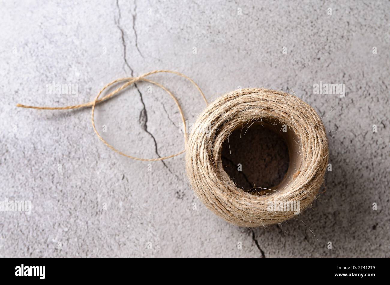 A roll of rustic thread on a stony grey background. Top view Stock ...