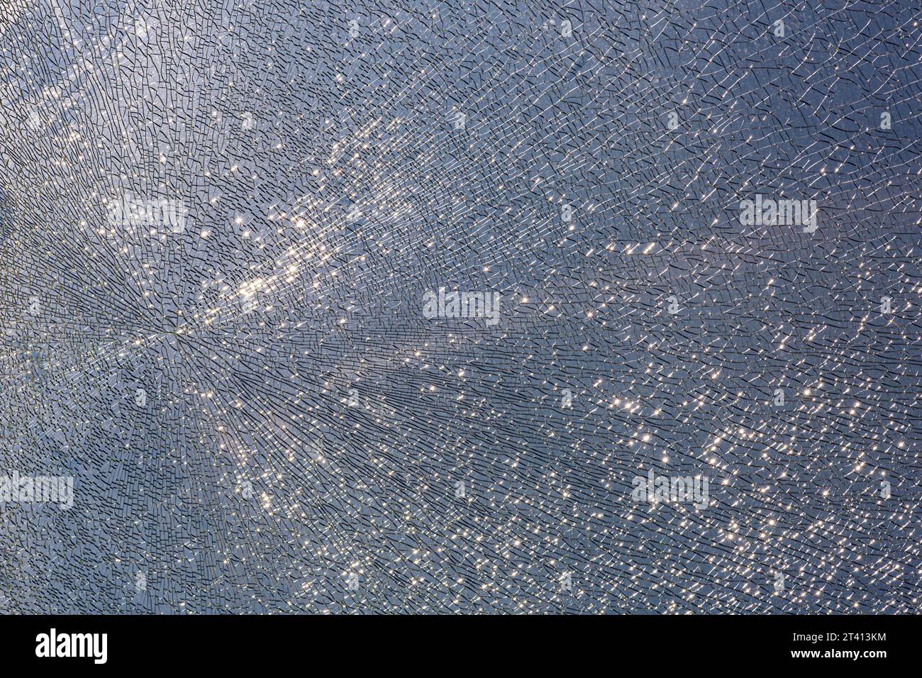 cracks at tempered glass, spoiled glass surface, texture background, blind windscreen close-up, nobody. Stock Photo