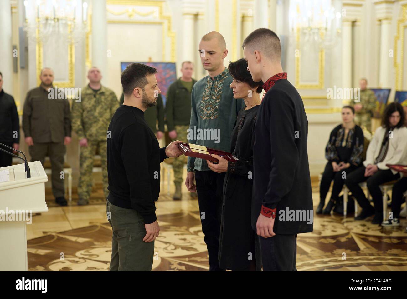 Kyiv, Ukraine. 27th Oct, 2023. Ukrainian President Volodymyr Zelenskyy, left, presents the family of a military hero the Golden Star Order during a ceremony at the Mariinsky Palace, October 27, 2023 in Kyiv, Ukraine. Credit: Ukraine Presidency/Ukrainian Presidential Press Office/Alamy Live News Stock Photo