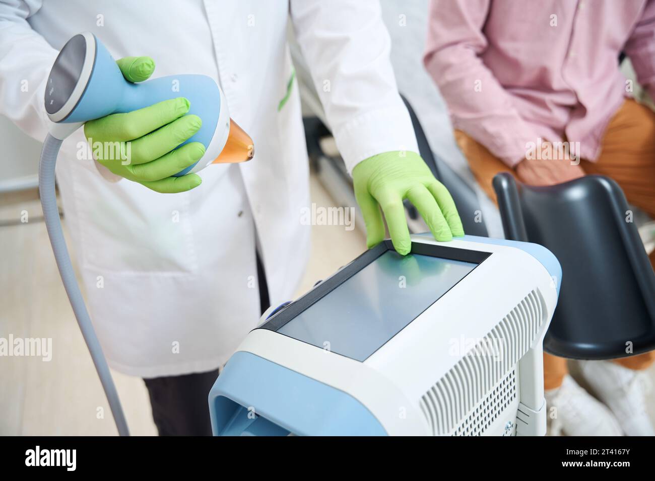 Prostrate Excersise Machine Physiotherapist sets up a device for procedure of stimulating prostate ...