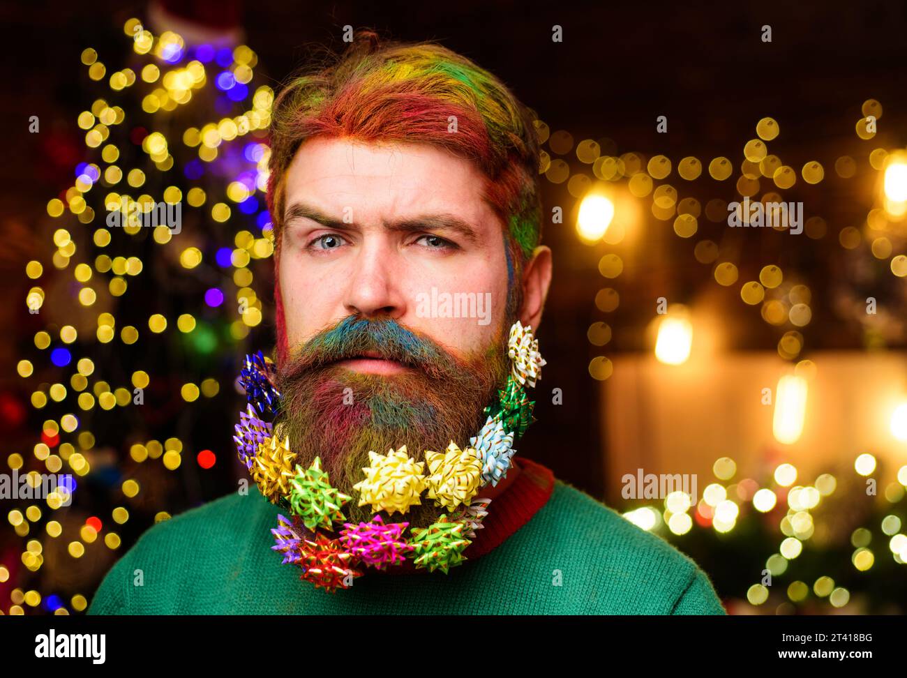 Merry Christmas. Happy New Year. Bearded man with dyed hair and decorated beard ready for New year party. Christmas beard decoration. Serious bearded Stock Photo