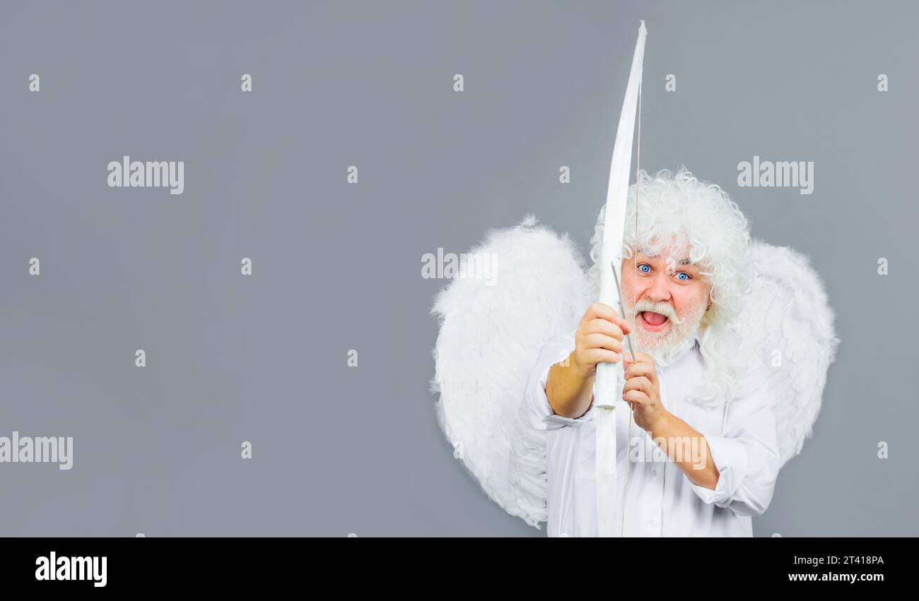 Valentines Day celebration. Arrow of love. Male angel with bow and arrow. Valentine angel with white wings shoots love arrow from bow on Valentines Stock Photo