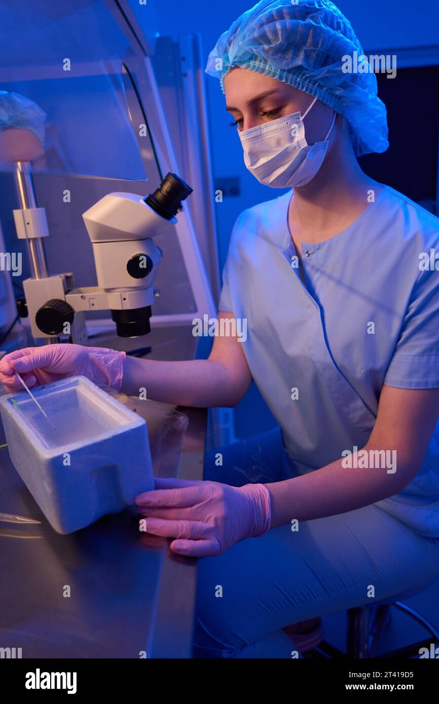 Lab scientist performing reproductive cell freezing procedure in liquid