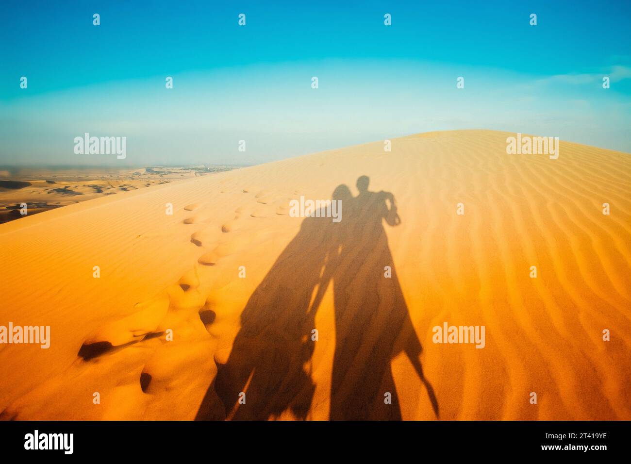 shadows of a couple in the desert dunes. Ica Peru Stock Photo